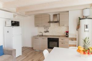a kitchen with a table and a white refrigerator at Villa AMARE in Caorle
