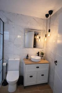 a bathroom with a toilet and a sink and a mirror at Belo Horizonte Guest House in A Guarda