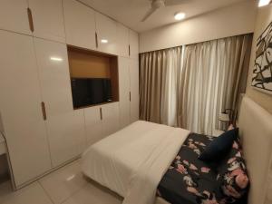 a small bedroom with a bed and a television at 1 BHK apartment in Bangalore
