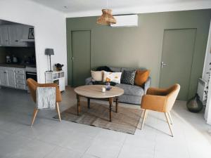 a living room with a couch and a table and chairs at La maison Françine in Sénas