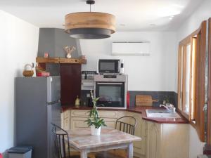 a kitchen with a table and a refrigerator at le balcon du Canigo' in Escaro