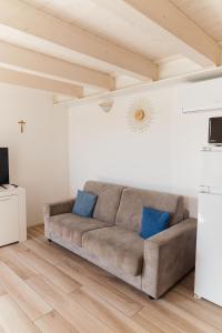 a couch in a living room with blue pillows at Villa AMARE in Caorle