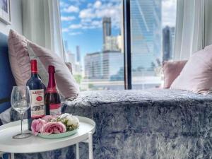 a table with two bottles of wine and a plate of flowers at Harbour Haven Sleep 7 Free Parking Free Tram to CBD in Melbourne
