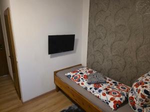 a room with a bed with a tv on a wall at Hotel Kaiser Friedrich in Bad Berleburg