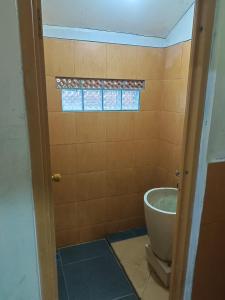 a bathroom with a toilet and a window at Glamping Camphills in Gunungpicung +16 photos