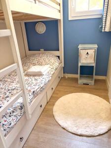 a bedroom with bunk beds and a rug at Maison villa Lilou, Pierre et vacances, avec piscine, vue sur le golf, plage à 10 min à pied in Moliets-et-Maa +19 photos