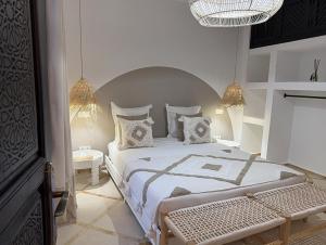 a bedroom with a large bed and a chandelier at Riad Al Jadd - 5 Bedrooms - Pool - Breakfast in Marrakesh +41 photos