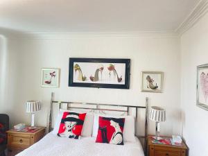 a bedroom with a bed with pillows and pictures on the wall at "The Celebration" Balcony Seafront Apartment in Eastbourne