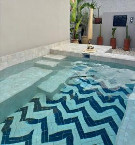 a swimming pool with a mosaic floor in a house at Riad Al Jadd - 5 Bedrooms - Pool - Breakfast in Marrakesh
