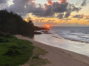 a sunset on a beach with the sun setting at Escale Gris Gris, breathtaking views and location! in Souillac