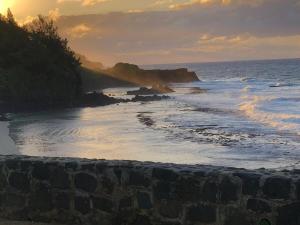 a sunset over a rocky beach with the ocean at Escale Gris Gris, breathtaking views and location! in Souillac
