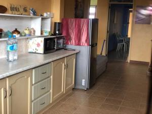 a kitchen with a refrigerator and a microwave at Escale Gris Gris, breathtaking views and location! in Souillac
