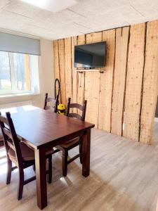 a dining room with a table and a television on a wall at Mājīgs dzīvoklis Aizputē in Aizpute