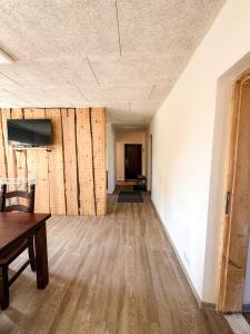 an empty room with a table and a wooden floor at Mājīgs dzīvoklis Aizputē in Aizpute +4 photos