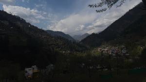 a view of a valley with a town and mountains at Moksh Jibhi Retreat in Jibhi