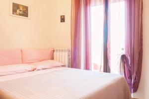 a bedroom with a bed with pink curtains and a window at La Casa dei Panorami in Castelsaraceno