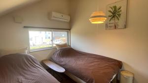 a small bedroom with a bed and a window at B&BHOUSE FAM in Ichinomiya