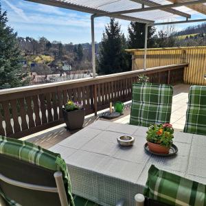 a patio with a table and chairs on a deck at Ferienhaus Luise in Sebnitz