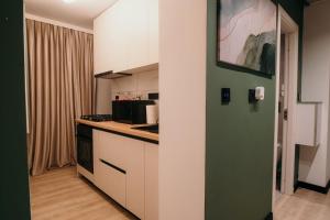 a kitchen with white cabinets and a green door at Sage Studio in Drobeta-Turnu Severin +6 photos