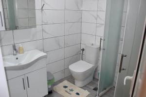 a white bathroom with a toilet and a sink at Art.Villa.Nike in Koinyra +34 photos