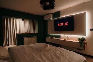 a bedroom with a bed and a tv on the wall at Sage Studio in Drobeta-Turnu Severin
