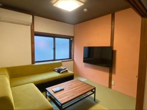 a living room with a couch and a coffee table at tot-an 14mins from Toyama station #HH7 in Toyama Station