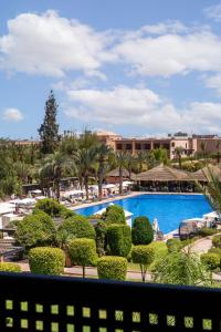 a view of the pool from the balcony of a resort at Kenzi Menara Palace & Resort in Marrakesh