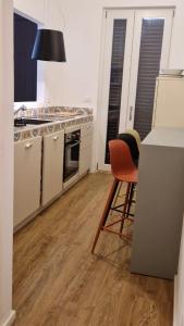a kitchen with a counter and a table and chairs at House 100 meters from the beach in Marina di Ragusa