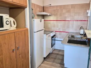 a kitchen with a white refrigerator and a sink at le coulinet in Andernos-les-Bains