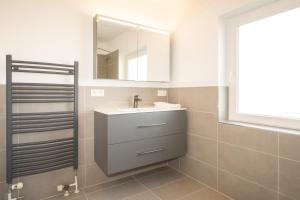 a bathroom with a sink and a mirror at Haus Roseneck App.1 in Hörnum +7 photos