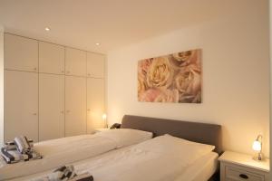 two beds in a bedroom with a painting on the wall at Haus Roseneck App.1 in Hörnum