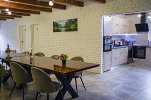 a kitchen with a table and chairs in a room at Cabana Moldovan Baisoara cu piscina interioara, ciubar, spa in Lunca Largă