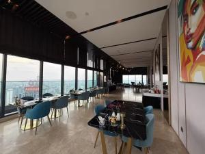 a dining room with tables and chairs and large windows at Star Residence KLCC By BluekeyKL in Kuala Lumpur