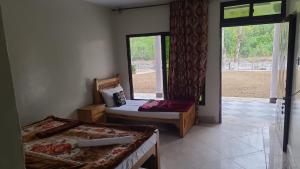 a room with two beds and a door with a window at Balakot View Hotel in Bauli