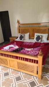 a large bed with a wooden frame in a room at Balakot View Hotel in Bauli
