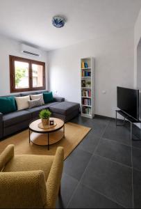 a living room with a couch and a tv at Casa Zeralda, privater Pool in Budoni