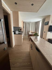 a kitchen with a counter and a dining room at BORMIO Apartment AL PRADAIS in Bormio