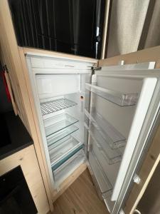 an empty refrigerator with its door open in a kitchen at BORMIO Apartment AL PRADAIS in Bormio
