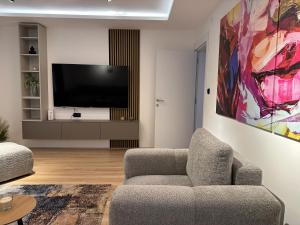 a living room with a couch and a flat screen tv at Urban Studio 018 in Niš