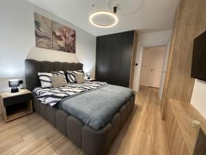 a bedroom with a large bed with a black headboard at Urban Studio 018 in Niš