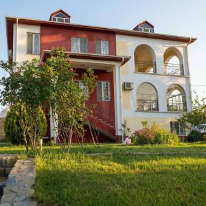 a red and white house with a tree in front of it at Sea View villa in Baku
