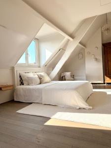 a bedroom with a white bed in a attic at Maison d'Artiste in Ghent