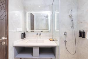 a white bathroom with a sink and a shower at Hotel HiStays, Dehradun in Dehradun +44 photos