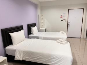 zwei Betten mit weißen Laken in einem Zimmer in der Unterkunft SC Residences in Surat Thani