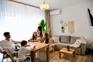 a group of people sitting around a table in a living room at Villa Antara in Szeged