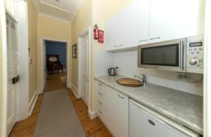 a kitchen with white cabinets and a microwave at Yankalilla Bay Homestead in Normanville