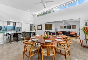 a dining room and living room with a table and chairs at Tenterfield Beachfront Luxury 4 Bedroom Holiday Home in Oak Beach