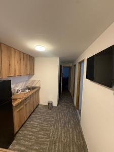 a kitchen with wooden cabinets and a flat screen tv at Antic Apartman in Bor