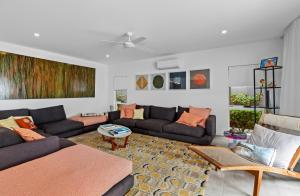 a living room with a couch and a table at Tenterfield Beachfront Luxury 4 Bedroom Holiday Home in Oak Beach +32 photos