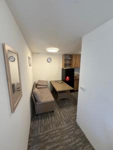 a small living room with a table and a chair at Antic Apartman in Bor